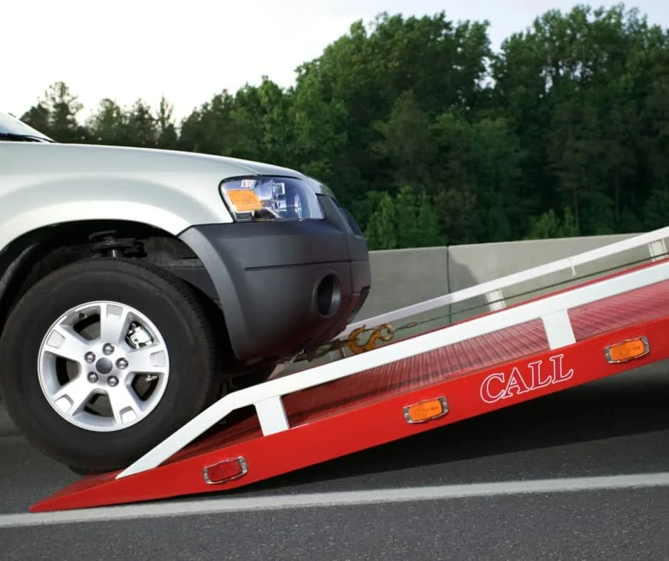 Baltimore tow truck loading a vehicle on a residential street